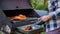 Senior woman grilling chicken meat for preparing eat in camping, elderly doing activity recreation and leisure picnic.