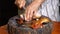 Senior woman hands cutting homemade roasted pork into pieces for dinner.