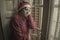 Senior woman having sad Christmas alone - mature retired lady 60s or 70s in Santa Claus hat depressed and emotional at home