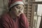 Senior woman having sad Christmas alone - mature retired lady 60s or 70s in Santa Claus hat depressed and emotional at home