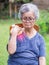 A senior woman having shoulder pain uses a Thai herbal compress ball on the shoulder. An old woman who has problems with her