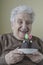 Senior woman with her birthday cake for age eighty