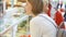 Senior woman and her daughter shopping in mall. Standing looking at glass case discussing purchases