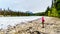 Senior woman hiker on the shore of the Athabasca River at the meeting of the rivers with the Whirlpool River in Jasper NP