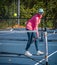 Senior woman hits a short backhand half volley during pickleball in fall