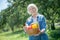 Senior woman holding a basket of seasonal vegetables
