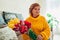 Senior woman holding bouquet of tulips from her kids at home. Mother`s day present