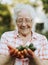 Senior woman holding organic jalapeno peppers from her own garden