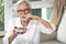 Senior woman holding plate of bad spoiled or expired food in her hand,rotten food,emitting a fetid smell or strong-smelling food,