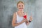 Senior woman holding red heart toy and show Thumbs up  in fitness gym. aged lady exercising.  Old female workout .Mature sport