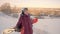 Senior woman holding snowboard behind her back.