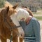 Senior woman hugs a Quarter horse