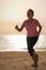 Senior woman jogging on sea beach