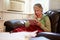 Senior Woman Keeping Warm Under Blanket With Photograph