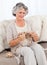 Senior woman knitting on her sofa