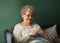 Senior woman knitting warm sock at home