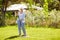 Senior woman with lawn rake working at garden