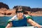 Senior Woman With Lifejacket on Her Chest Climbs into a Boat After Swimming Lake Powell