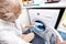 Senior woman loading towel in washing machine at home