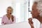 Senior Woman Looking At Reflection In Bathroom Mirror Putting On Make Up