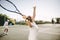 Senior woman making a serve while playing tennis