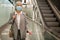 Senior woman in mask beside escalator in mall