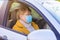 Senior woman in a medical face mask on the passenger seat in the car. Driving to the hospital during Coronavirus pandemic conc