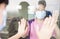 Senior woman in medical mask communicates with her daughter through the window. Elderly quarantined, isolated. Pandemic coronaviru