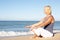 Senior Woman Meditating On Beach