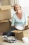 Senior Woman Moving Home And Packing Boxes