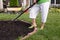 Senior woman mulching a flowerbed