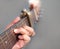 Senior woman musician hand holds classic wooden guitar neck.