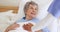 Senior woman, nurse hands and support in bed at home, care and help in rehabilitation. Happy caregiver, bedroom and