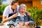 Senior woman in nursing home with nurse in garden