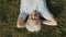 Senior woman, pensioner lying on the grass with hands under her head. overhead close up shot