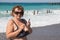 Senior woman photographing by telephone at beach