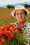 Senior woman picking flowers on the poppy field