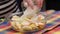 senior woman pouring sugar in glass bowl with chopped apples during making apple pie