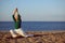 Senior woman practicing yoga on beach