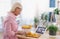 Senior woman preparing food in kitchen indoors, following food vlogger.