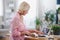 Senior woman preparing food in kitchen indoors, following food vlogger.