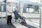 Senior woman pushing man in wheelchair
