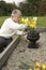 Senior woman putting flowers on a grave