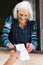 Senior woman receiving retirement check at home