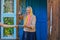 Senior woman receiving retirement money on the porch near her house. Grandmother holds money.