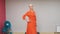 Senior woman in red dress walking on catwalk at fashion show. Elegant mature woman showing new designer clothes