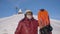 Senior woman in red jacket holds skateboard on snowy hill