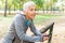 Senior Woman Relax Listening Music With Phone After Jogging In Forest