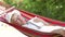 Senior Woman Relaxing In Hammock With Book