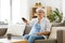 Senior woman with remote watching tv at home